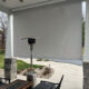 View looking into exterior solar shade in white grey with outdoor heater